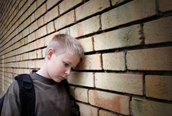 Boy leaning against a wall